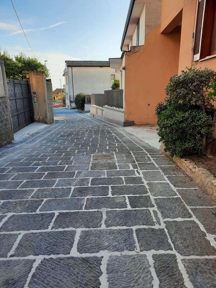 Una stradina del borgo, lastricata in pietra scura.