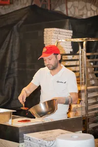 Un pizzaiolo con il cappellino rosso.