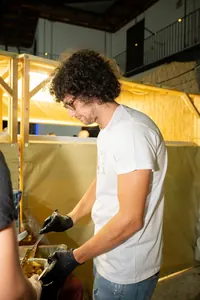Un ragazzo ai fornelli dietro lo stand illuminato.